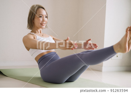 A young woman doing yoga, core training, and muscle training 91263594