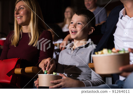 Family with son watching movie and eating popcorn in cinema Family with son watching movie and eating popcorn in cinema 91264011