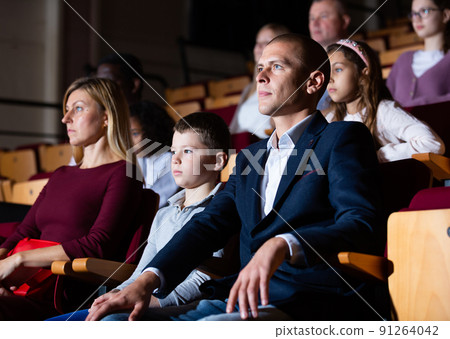 caucasian family sitting at premiere in theatrical hall caucasian family sitting at premiere in theatrical hall 91264042
