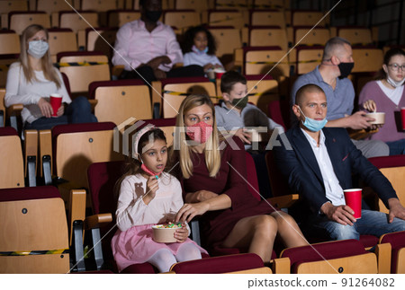 caucasian family sitting at premiere in cinema during pandemic 91264082