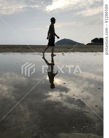 一個行走的人在水面上移動的剪影 一個行走的人在水面上移動的剪影 91266589