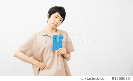 中年婦女拿著養老金簿，表情不安 91268680