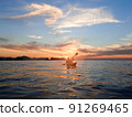 A person rowing a canoe in the sunset 91269465