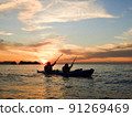 Two people rowing a sea kayak in the evening 91269469