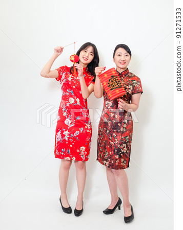 身穿傳統旗袍的亞洲女性白色背景上手持寫著中字“福”（意思為祝福、幸福）的燈籠慶祝新年。 91271533
