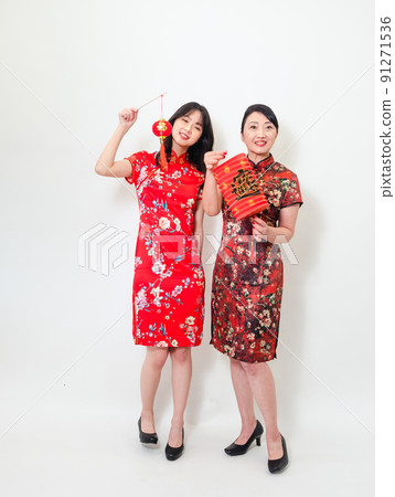 Asian woman in traditional cheongsam holding lantern with Chinese character "Fu" (meaning blessing, happiness) on white background celebrating New Year. 91271536