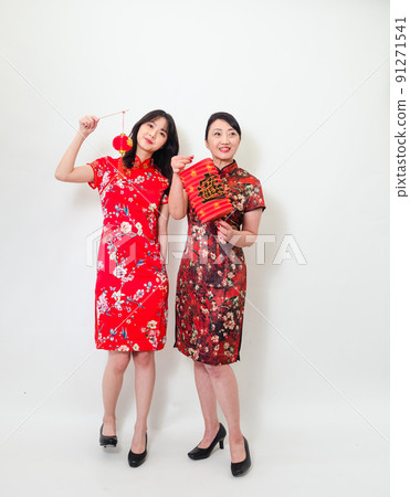Asian woman in traditional cheongsam holding lantern with Chinese character "Fu" (meaning blessing, happiness) on white background celebrating New Year. 91271541