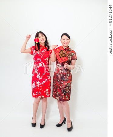 Asian woman in traditional cheongsam holding lantern with Chinese character "Fu" (meaning blessing, happiness) on white background celebrating New Year. 91271544