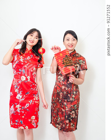 身穿傳統旗袍的亞洲女性白色背景上手持寫著中字“福”(意思為祝福、幸福)的燈籠慶祝新年。 身穿傳統旗袍的亞洲女性白色背景上手持寫著中字“福”(意思為祝福、幸福)的燈籠慶祝新年。 91271552