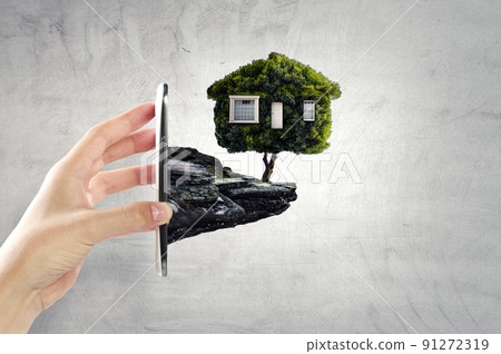 Hand holding green house . Mixed media 91272319