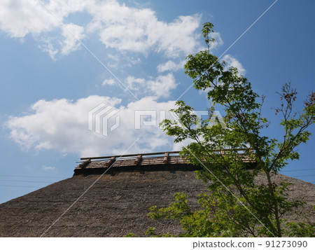 藍天、白雲、稻草屋頂和新鮮的綠樹 91273090