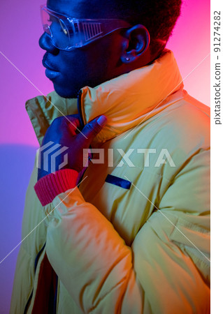 Urban guy. Street wear. Male fashion. Vivid neon. Stylish confident young man portrait in casual clothes colorful bright glowing light. 91274282