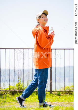 A young and cute woman walking with a plastic bottle for hydration in the sunny sunshine A young and cute woman walking with a plastic bottle for hydration in the sunny sunshine 91275221