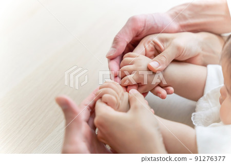 Baby holding hands and family Family image 91276377
