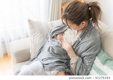 Women breastfeeding with a nursing cover 91276383