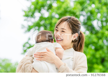 A woman holding a baby 91276388