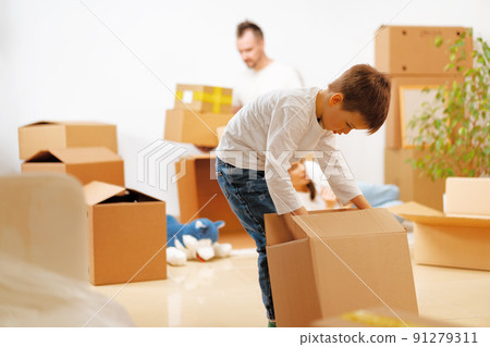 Little boy packing a moving box for a new home Little boy packing a moving box for a new home 91279311