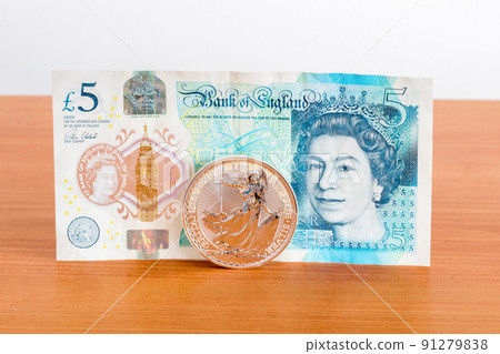1oz silver coin 2 GBP Britannia coin and Bank of England 5 GBP polymer note. 91279838