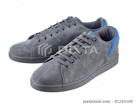 Beautiful pair of fashionable modern sneakers made of gray suede with inserts of bright blue suede in the back, lace-up, isolated on a white background. Beautiful pair of fashionable modern sneakers made of gray suede with inserts of bright blue suede in the back, lace-up, isolated on a white background. 91283100
