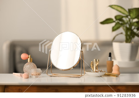 Mirror, jewelry and makeup products on white table indoors 91283936
