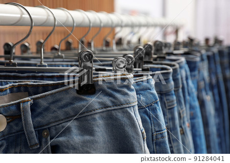 Rack with different stylish jeans, closeup view Rack with different stylish jeans, closeup view 91284041
