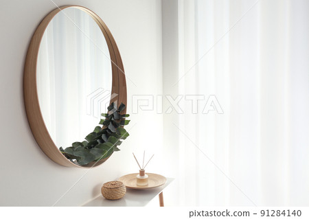 Round mirror with wooden frame in light room Round mirror with wooden frame in light room 91284140