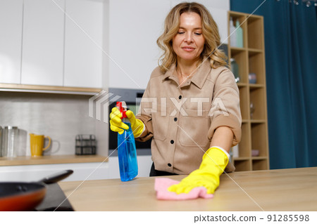 Portrait of adult woman cleaning kitchen counter 91285598