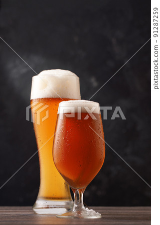 Two glasses of beer on black background. 91287259