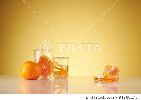 Front view of orange decorated with glassware and transparent podium in brown background 91288175