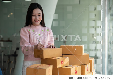 Close up hand of young woman small business owner online shopping at home preparing package product on background. SME entrepreneur or freelance life style concept. Close up hand of young woman small business owner online shopping at home preparing package product on background. SME entrepreneur or freelance life style concept. 91288729
