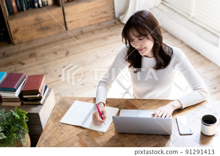 一個女人在別緻的房間裡使用筆記本電腦 一個女人在別緻的房間裡使用筆記本電腦 91291413