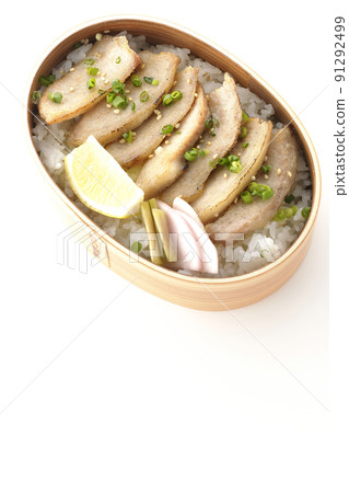 A bird's-eye view of a yakiniku bento box containing pickles, cut lemons and pork toro on a white background A bird's-eye view of a yakiniku bento box containing pickles, cut lemons and pork toro on a white background 91292499