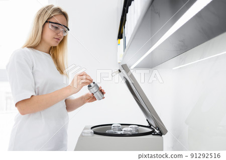 Female doctor putting test tube to metal container. Plasmolifting procedure Female doctor putting test tube to metal container. Plasmolifting procedure 91292516