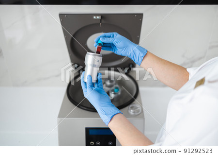 Beautician doctor's hands put test tube with blood in centrifuge container. Rejuvenation plasmolifting procedure Beautician doctor's hands put test tube with blood in centrifuge container. Rejuvenation plasmolifting procedure 91292523