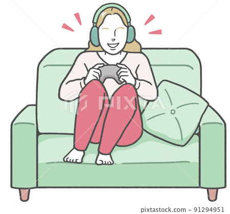 A young western woman wearing headphones, sitting on the couch and enjoying a video game alone A young western woman wearing headphones, sitting on the couch and enjoying a video game alone 91294951