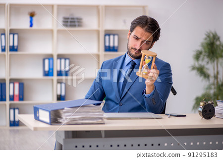 Young male employee in wheel-chair in time management concept Young male employee in wheel-chair in time management concept 91295183