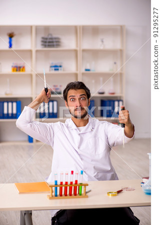 Young male chemist working at the lab 91295277