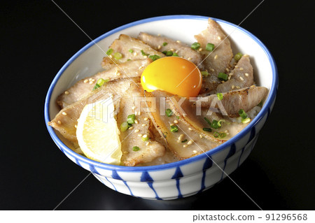 Pork toro bowl with cut lemon and egg yolk, grilled meat bowl photographed on a black background Pork toro bowl with cut lemon and egg yolk, grilled meat bowl photographed on a black background 91296568
