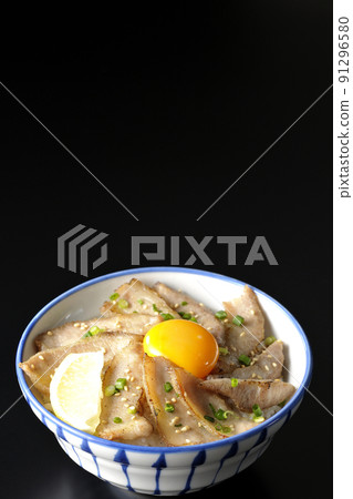 帶切檸檬和蛋黃的豬肉托羅碗，黑色背景上拍攝的烤肉碗 91296580