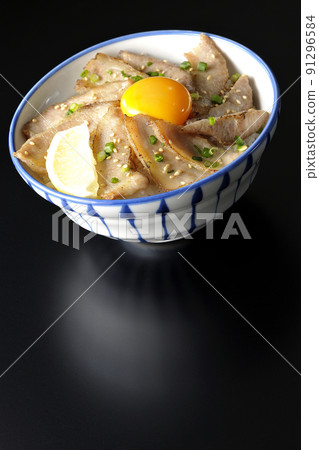 Pork toro bowl with cut lemon and egg yolk, grilled meat bowl photographed on a black background Pork toro bowl with cut lemon and egg yolk, grilled meat bowl photographed on a black background 91296584