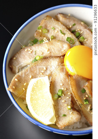 A bird's-eye view of a pork bowl with cut lemon and egg yolk and a grilled meat bowl on a black background A bird's-eye view of a pork bowl with cut lemon and egg yolk and a grilled meat bowl on a black background 91296633