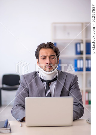 Young male employee after car accident working in the office Young male employee after car accident working in the office 91297687