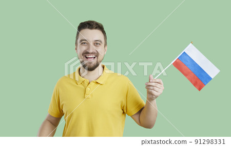 Happy Russian man isolated on green background holding flag of Russian Federation Happy Russian man isolated on green background holding flag of Russian Federation 91298331