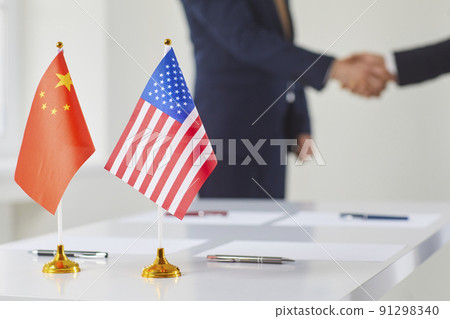 Flags of China and America against background of handshakes of representatives of these countries. Flags of China and America against background of handshakes of representatives of these countries. 91298340