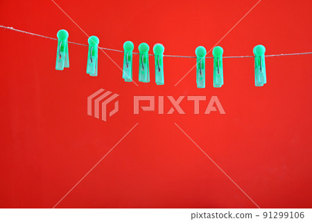 Green clothespins hanging on rope Green clothespins hanging on rope 91299106
