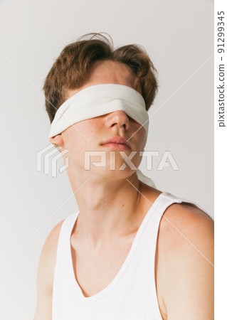 Portrait of young man with blindfold sitting on chair isolated on white studio background. Concept of fashion, youth, emotions, facial expression, ad Portrait of young man with blindfold sitting on chair isolated on white studio background. Concept of fashion, youth, emotions, facial expression, ad 91299345