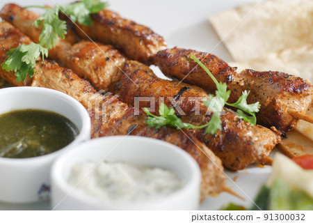Seekh Kabab, Naan bread, and sauce on a plate  91300032