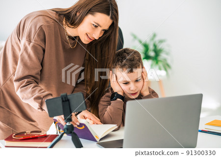Mother helps her son with online distance education 91300330