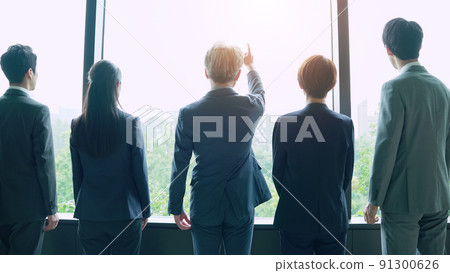 Back view of a business group looking out from the window Back view of a business group looking out from the window 91300626