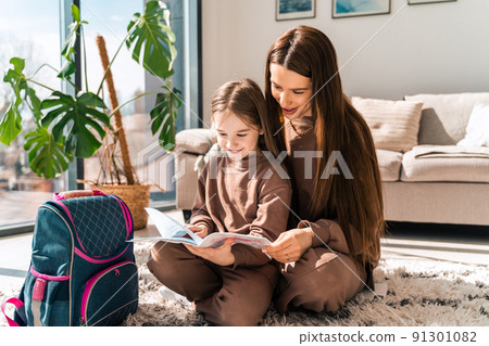 Daughter shows her school diary to mother Daughter shows her school diary to mother 91301082